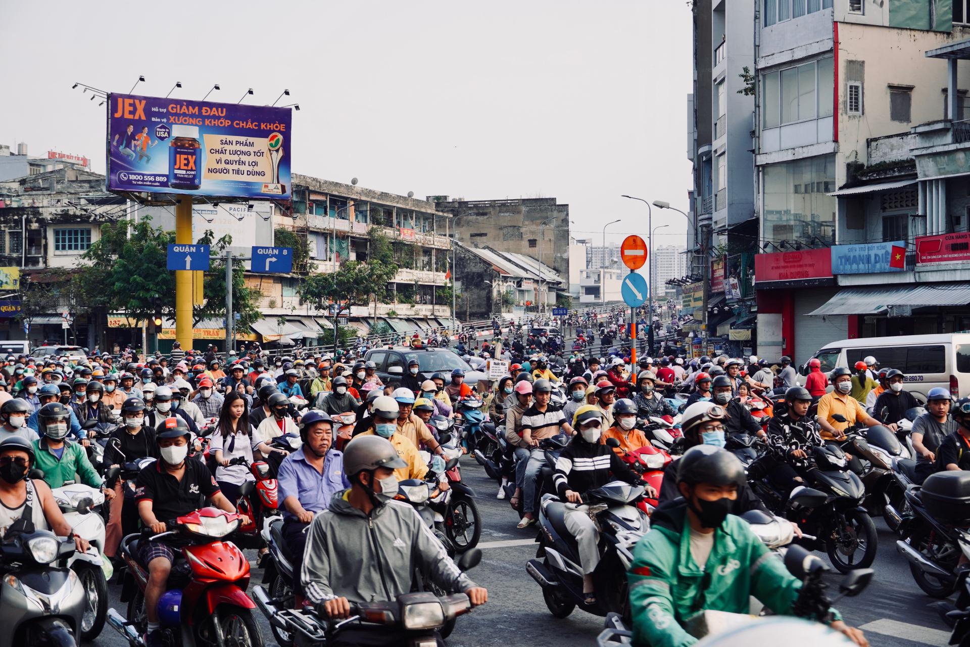 A crowded street filled with motorbikes in a busy Vietnamese city, capturing urban chaos.